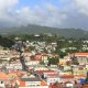St. George's, Grenada, seen from above, with houses climbing the steep hillside and mountains rising behind the town